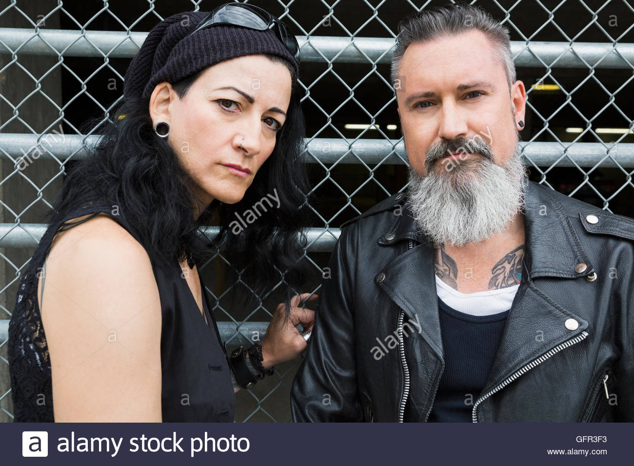 Portrait tough cool mature couple at fence Stock Photo