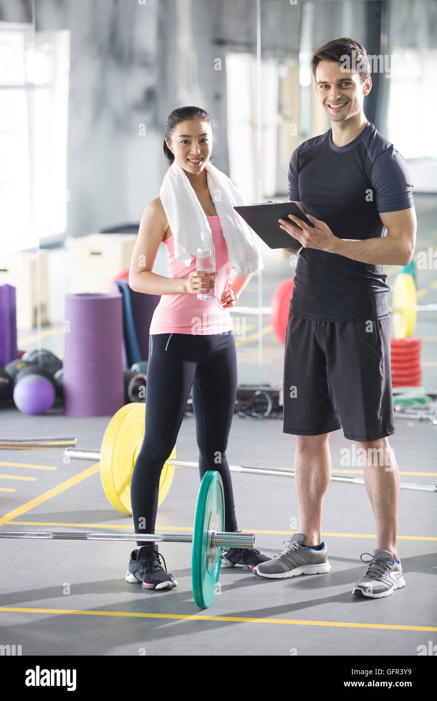 Young Chinese woman working with trainer at gym Stock Photo - Alamy
