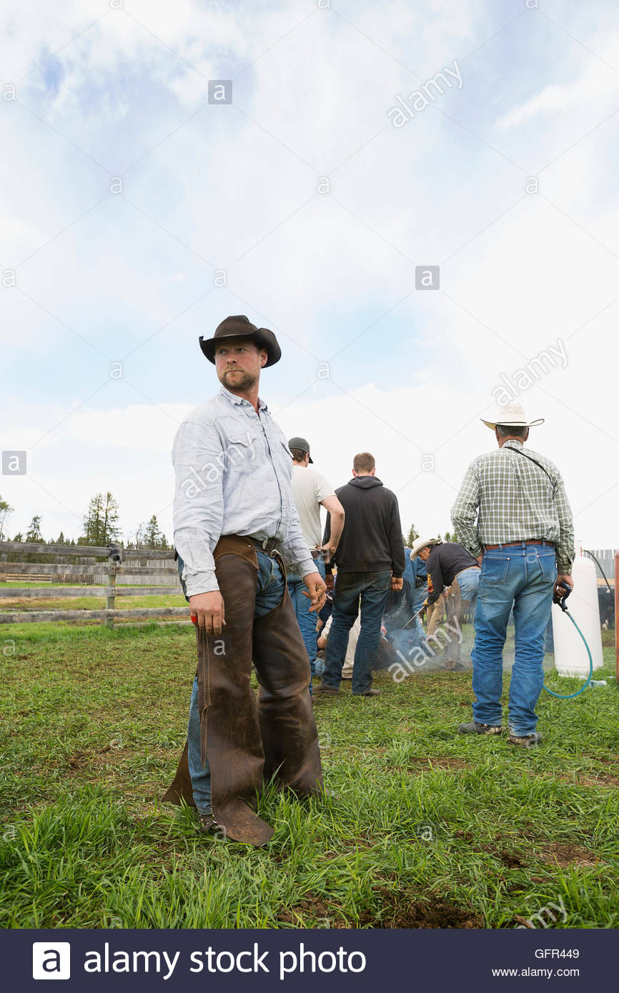 Cattle rancher in cowboy hat and chaps looking away Stock Photo
