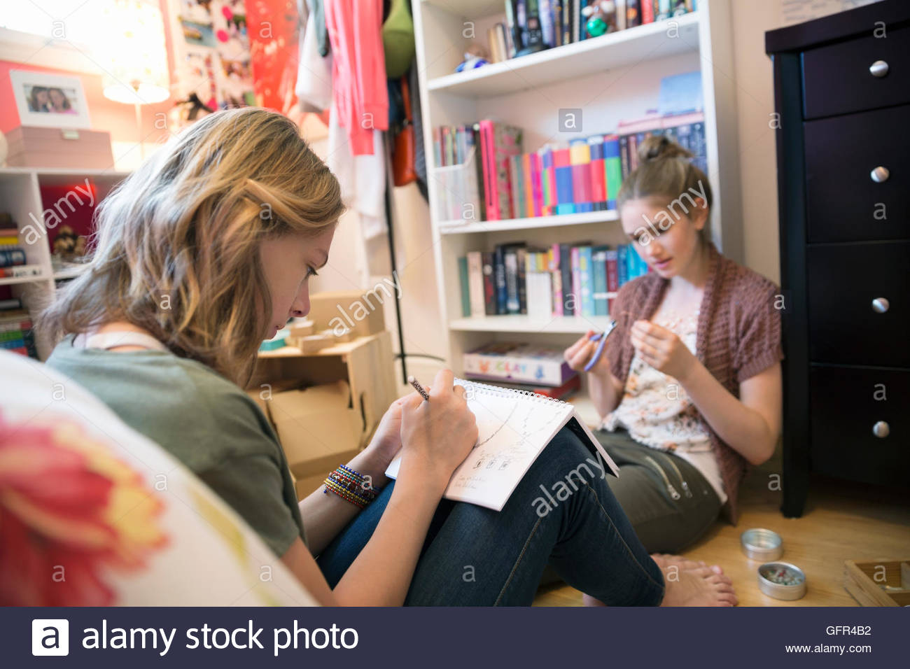Girls designing and making jewelry in bedroom Stock Photo