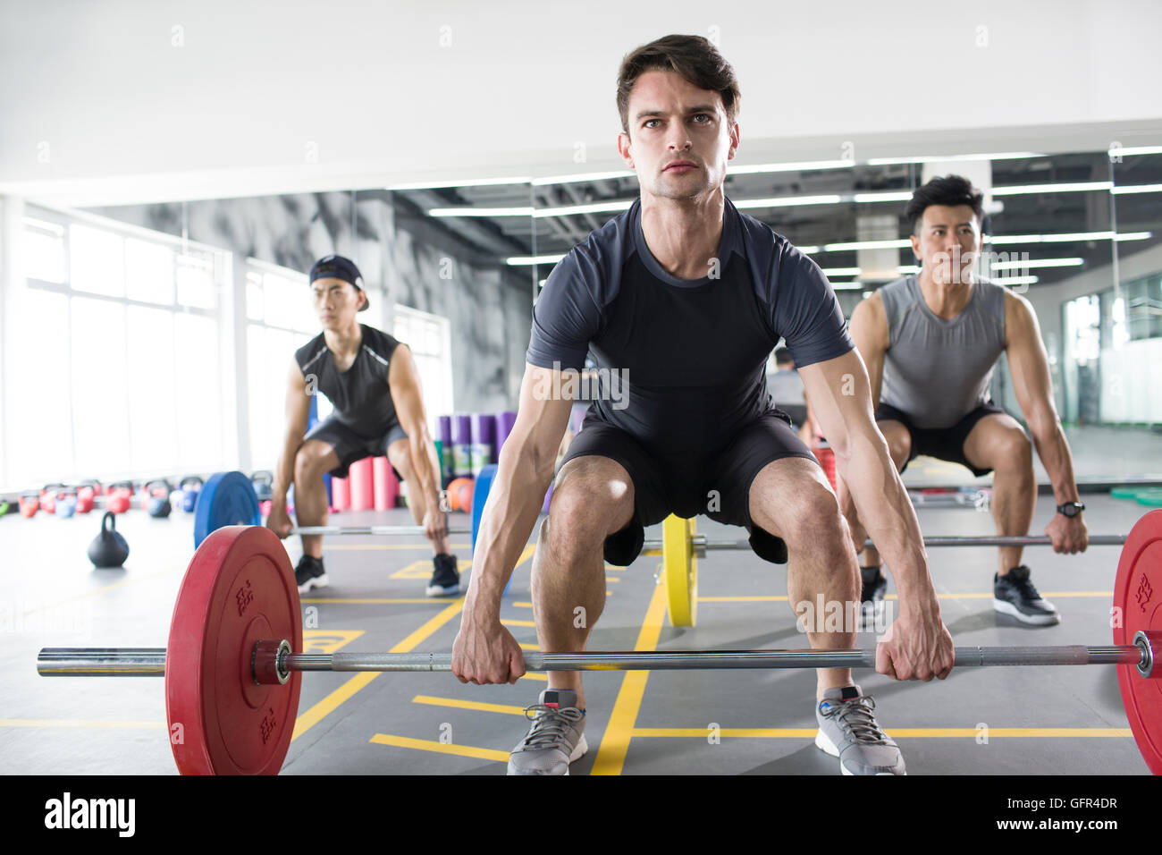 Young adult lifting barbells at gym Stock Photo Alamy