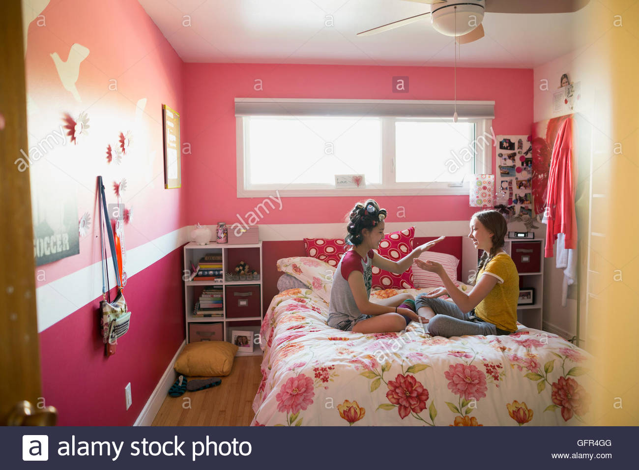 Girls playing clapping game on bed Stock Photo