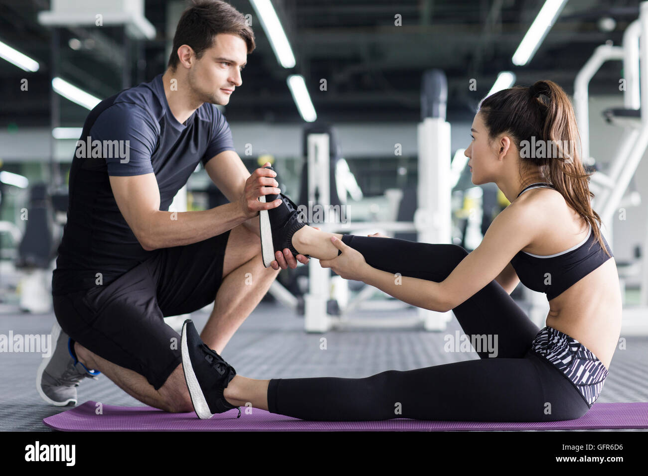 Young Chinese woman working with trainer at gym Stock Photo - Alamy