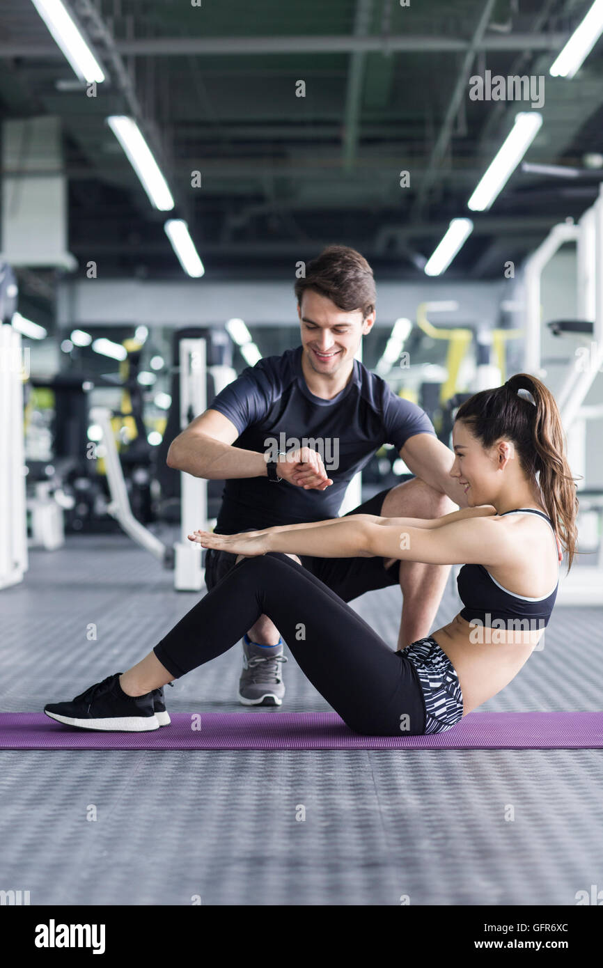 Young Chinese woman working with trainer at gym Stock Photo - Alamy