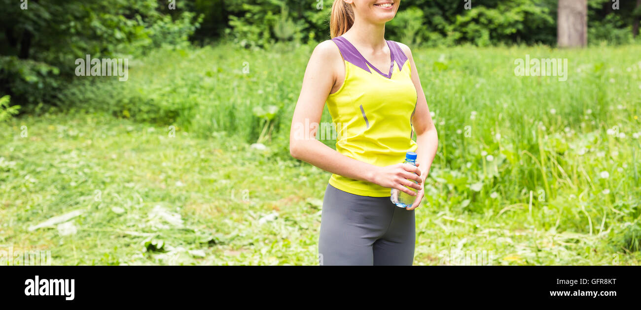 Fit woman outdoors holding a bottle of water Stock Photo - Alamy