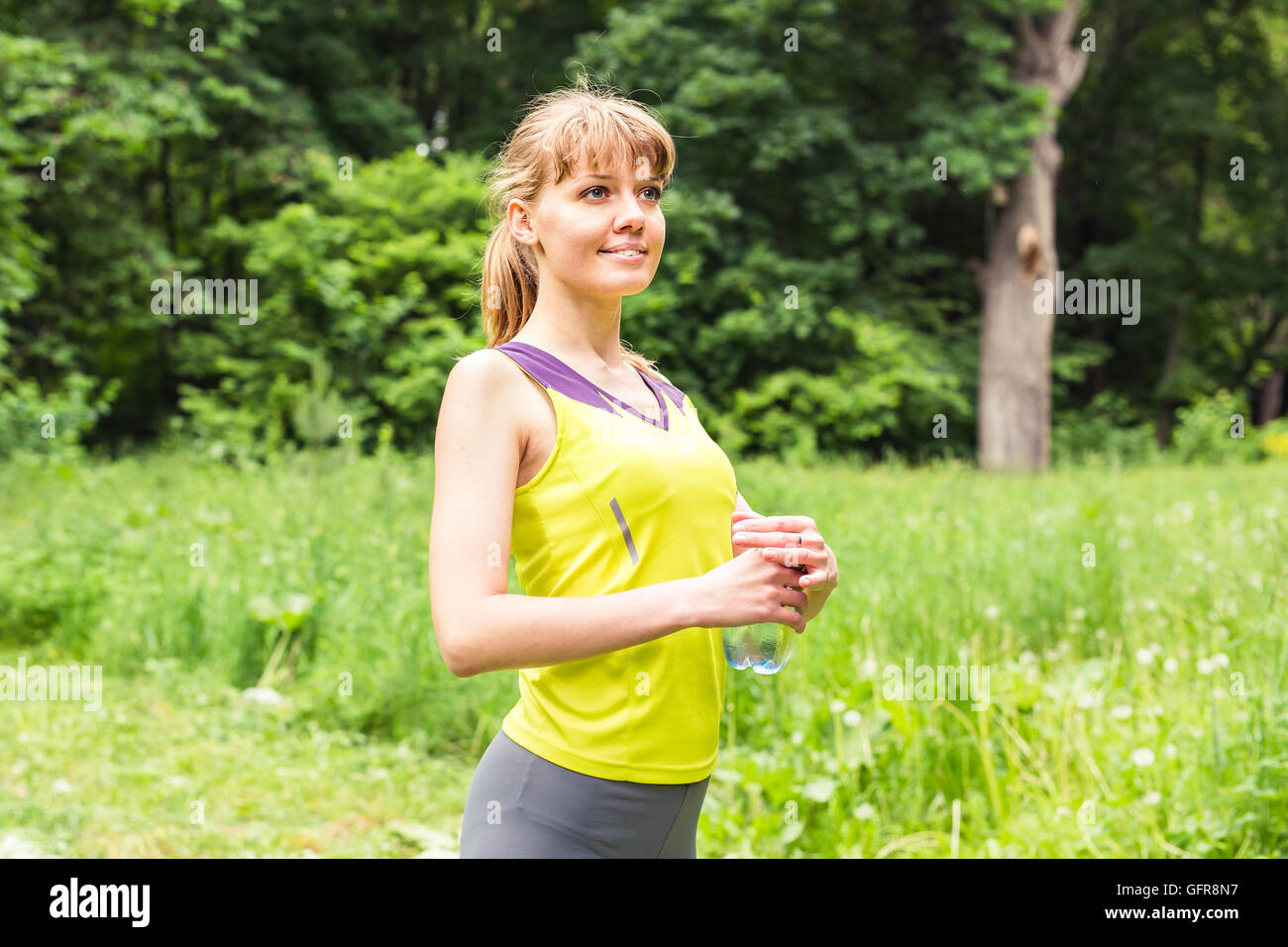 Fit woman outdoors holding a bottle of water Stock Photo - Alamy