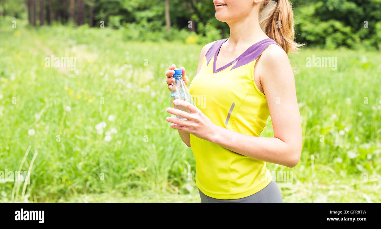 Fit woman outdoors holding a bottle of water Stock Photo - Alamy