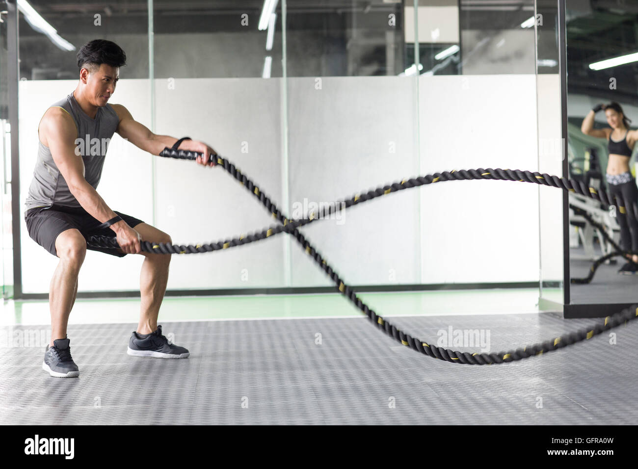 Chinese Rope Combat Young Chinese man exercising with battling rope at gym Stock Photo - Alamy