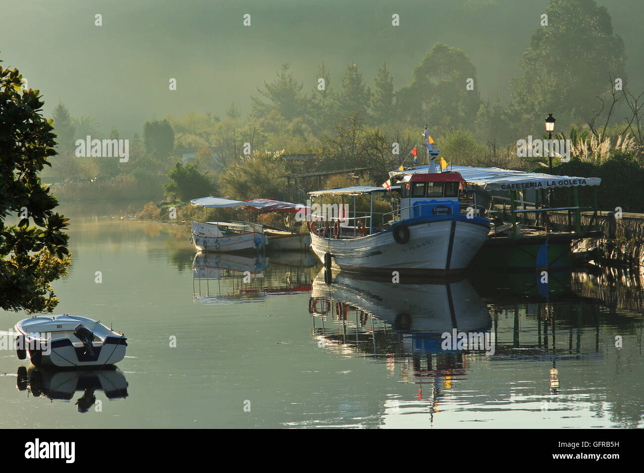 Early morning river view with boats and sunny hazy landscape Stock Photo