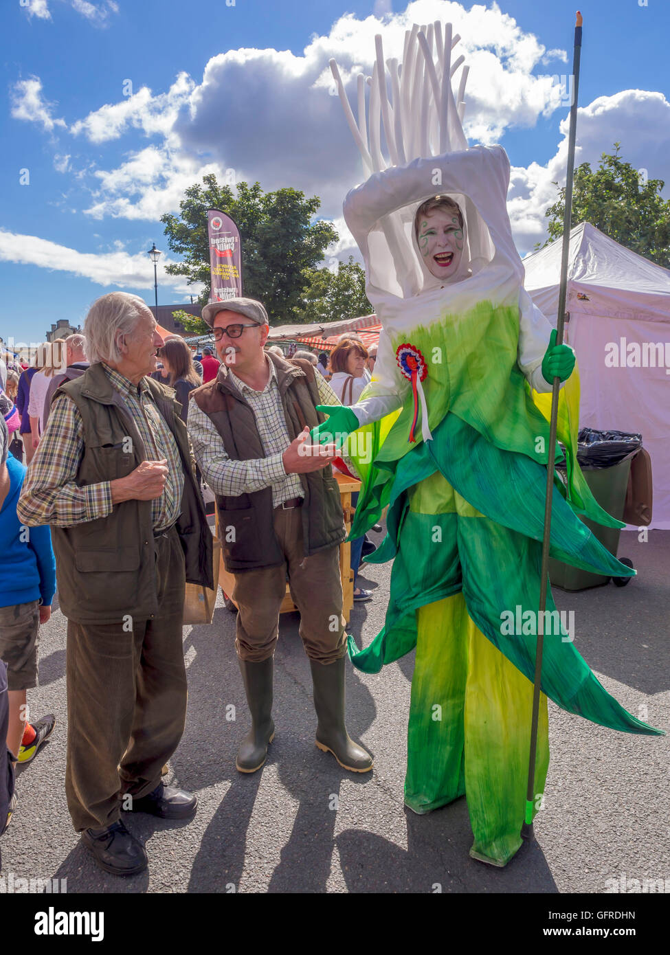 The Annual Saltburn Food Festival a woman on stilts dressed as a leek promoting Yorkshire Food with two men dressed as farmers Stock Photo