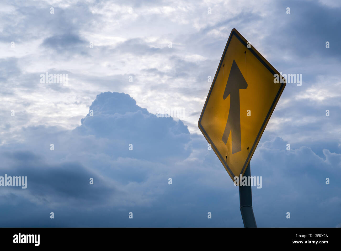 crossroad warning road sign with rain cloud background Stock Photo