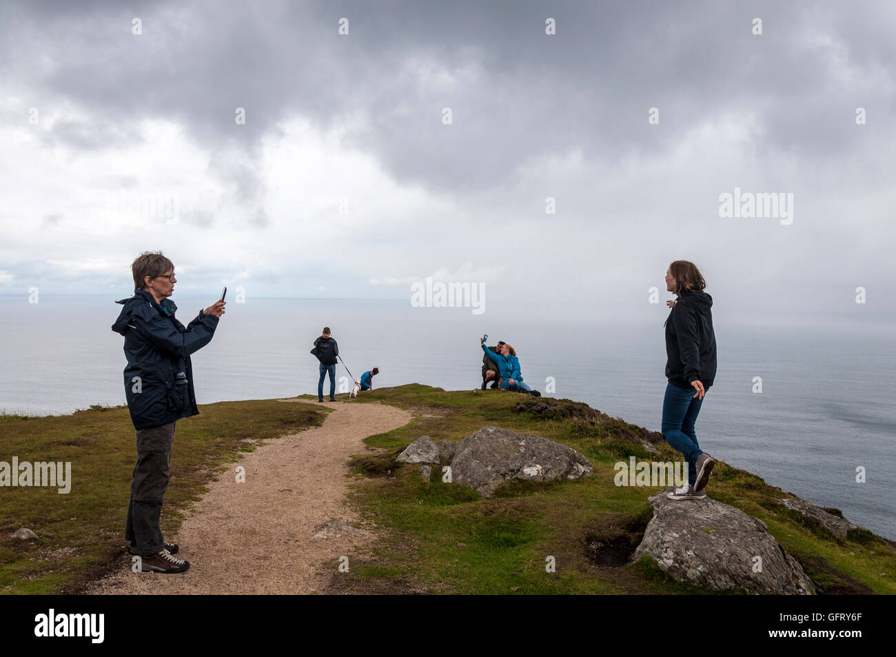 Tourists take photographs at Slieve League sea cliffs near Teelin, County Donegal, Ireland on the Wild Atlantic Way Stock Photo