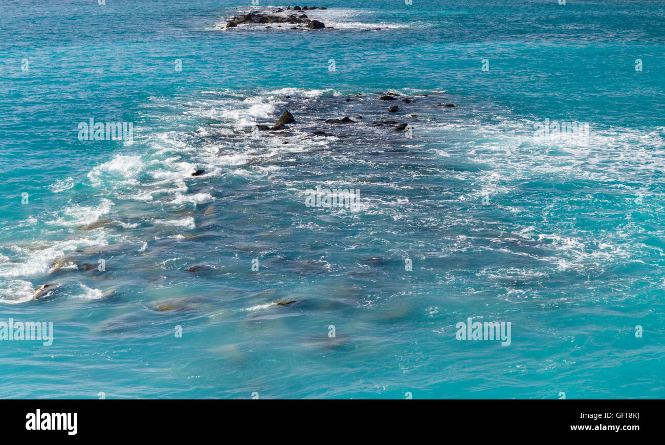 Waves, rocks and stones on the open sea from above. Deep turquoise water Stock Photo