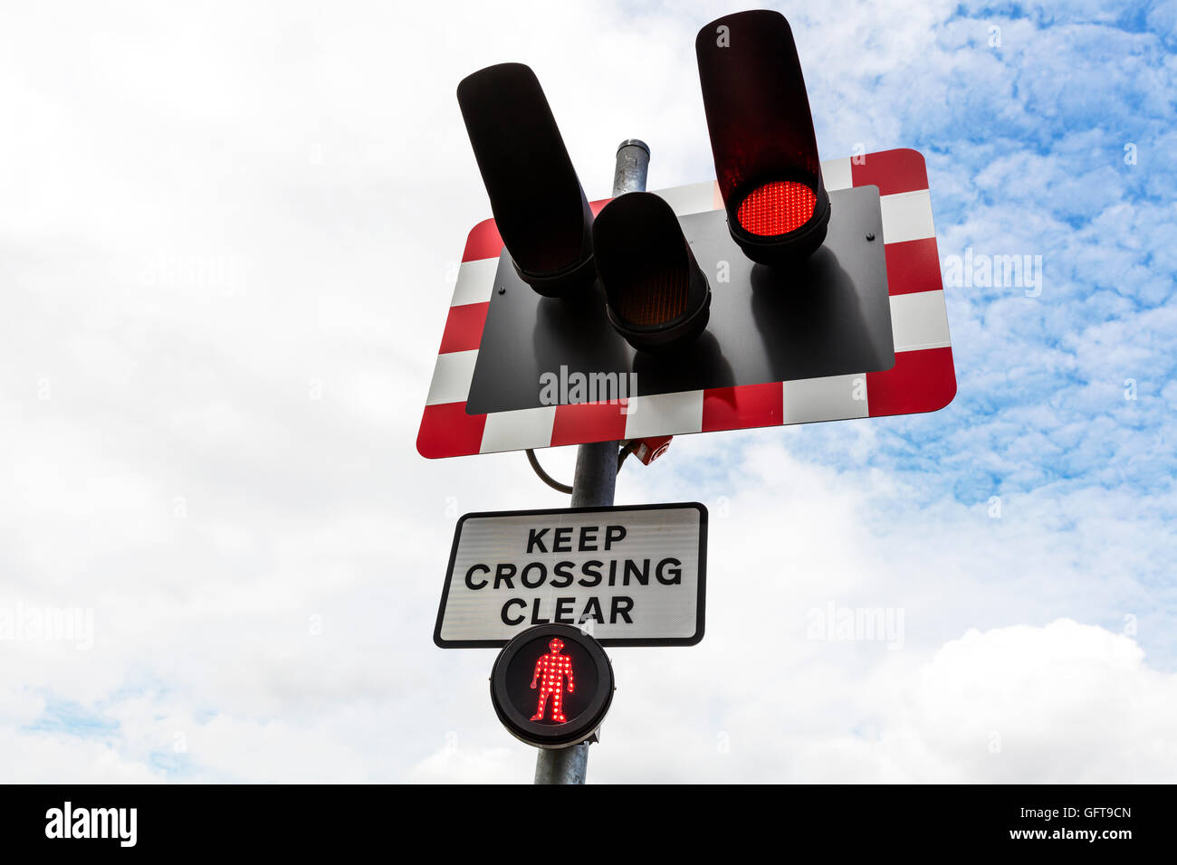 Level crossing lights flashing warning of train coming danger do not cross keep crossing clear sign UK England GB Stock Photo