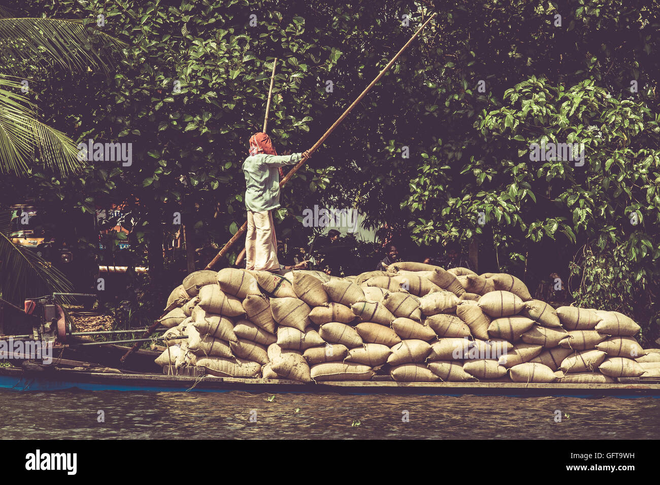Allepey, Kerala, India March 31, 2015: Indian man transport dwell with rice for boats. backwaters canoe in state,. Cochin Stock Photo