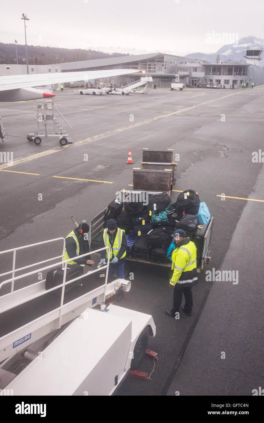 Baggage handlers loading luggage on to plane at Chambery Airport, France, Europe Stock Photo