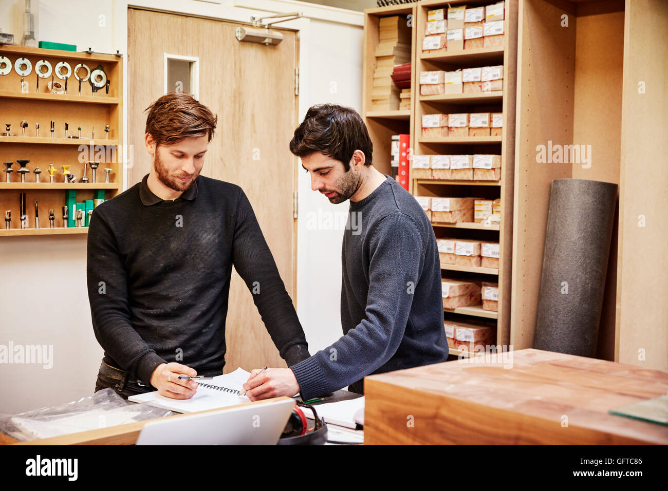 A furniture workshop ,Two people discussing a design referring to drawings Stock Photo