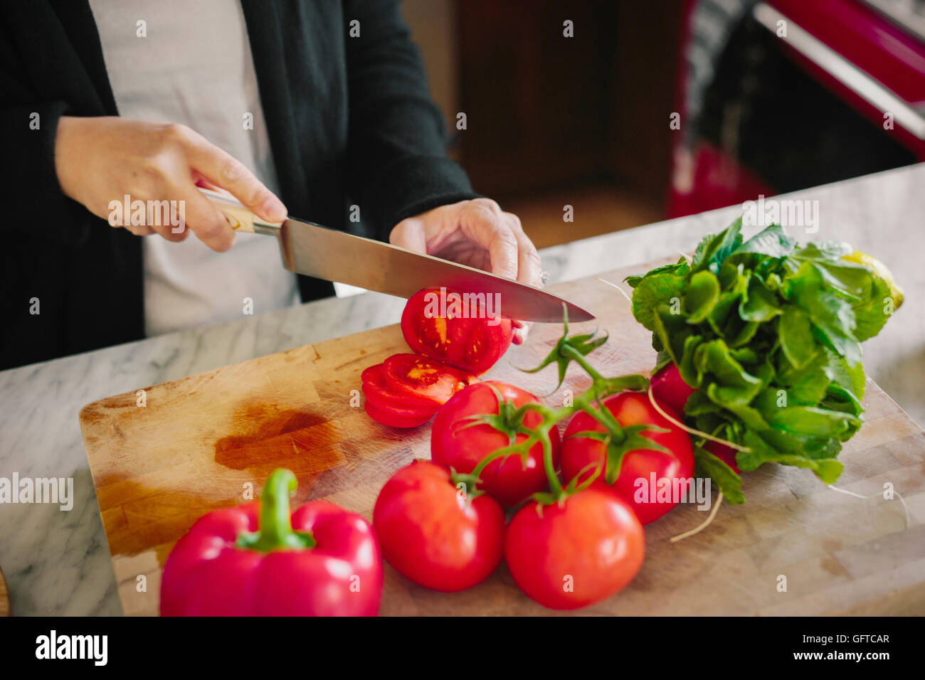 A woman using a sharp knife slicing tomatoes Stock Photo - Alamy