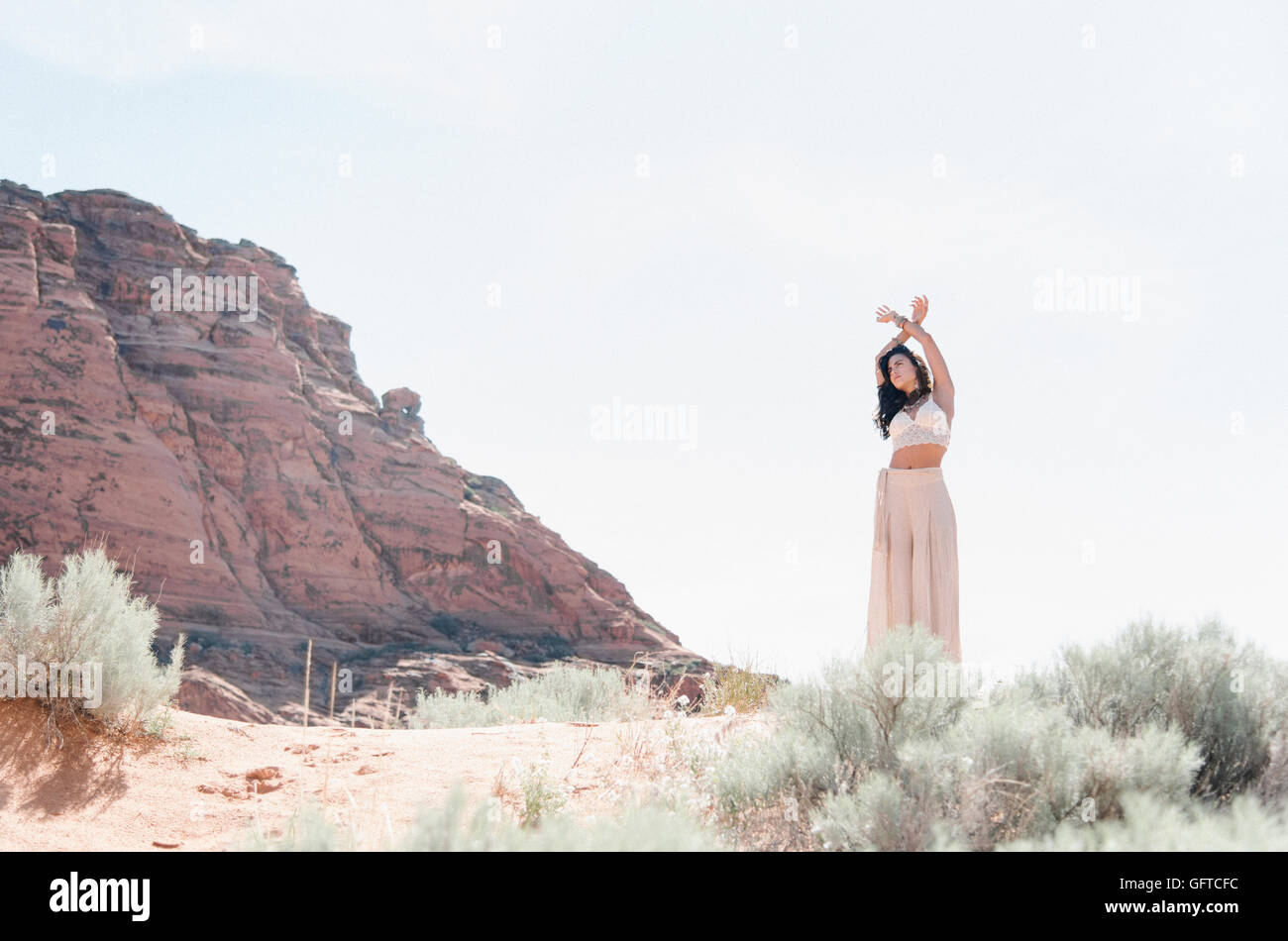 Young woman with long brown hair wearing a long white dress standing in ...