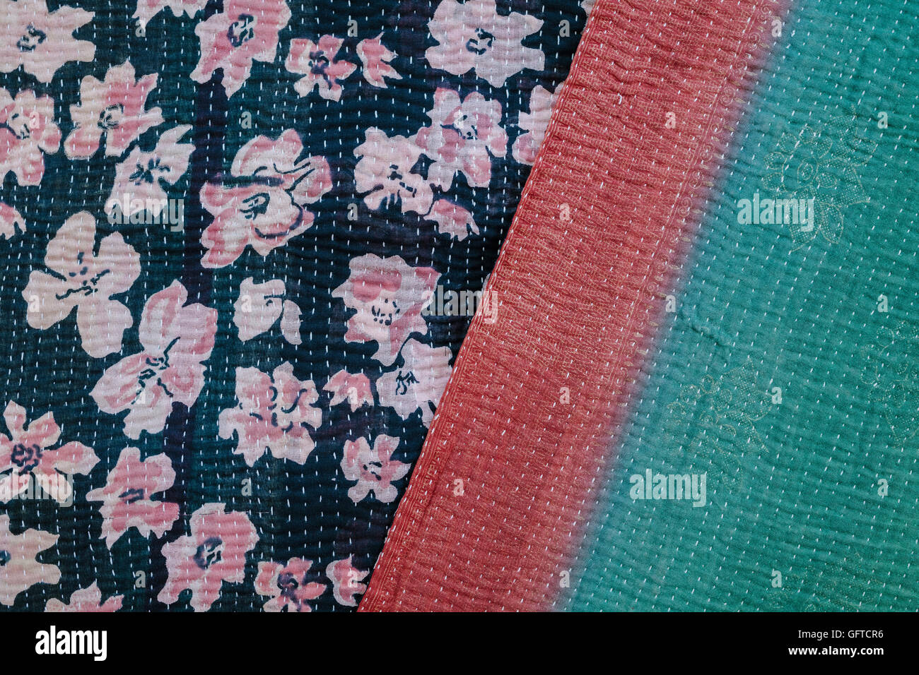 Close up of a fabric bedspread or throw with different fabrics sewn and