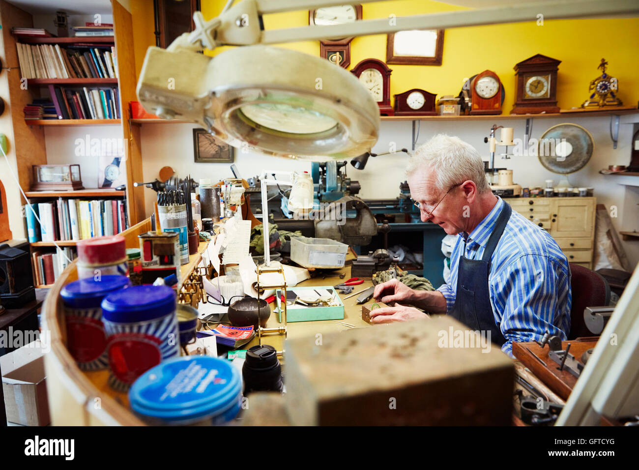 A clock maker busy in his Stock Photo Alamy
