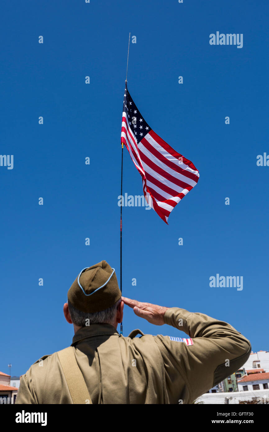 Man in second world war US army uniform salutes the American flag Stock Photo