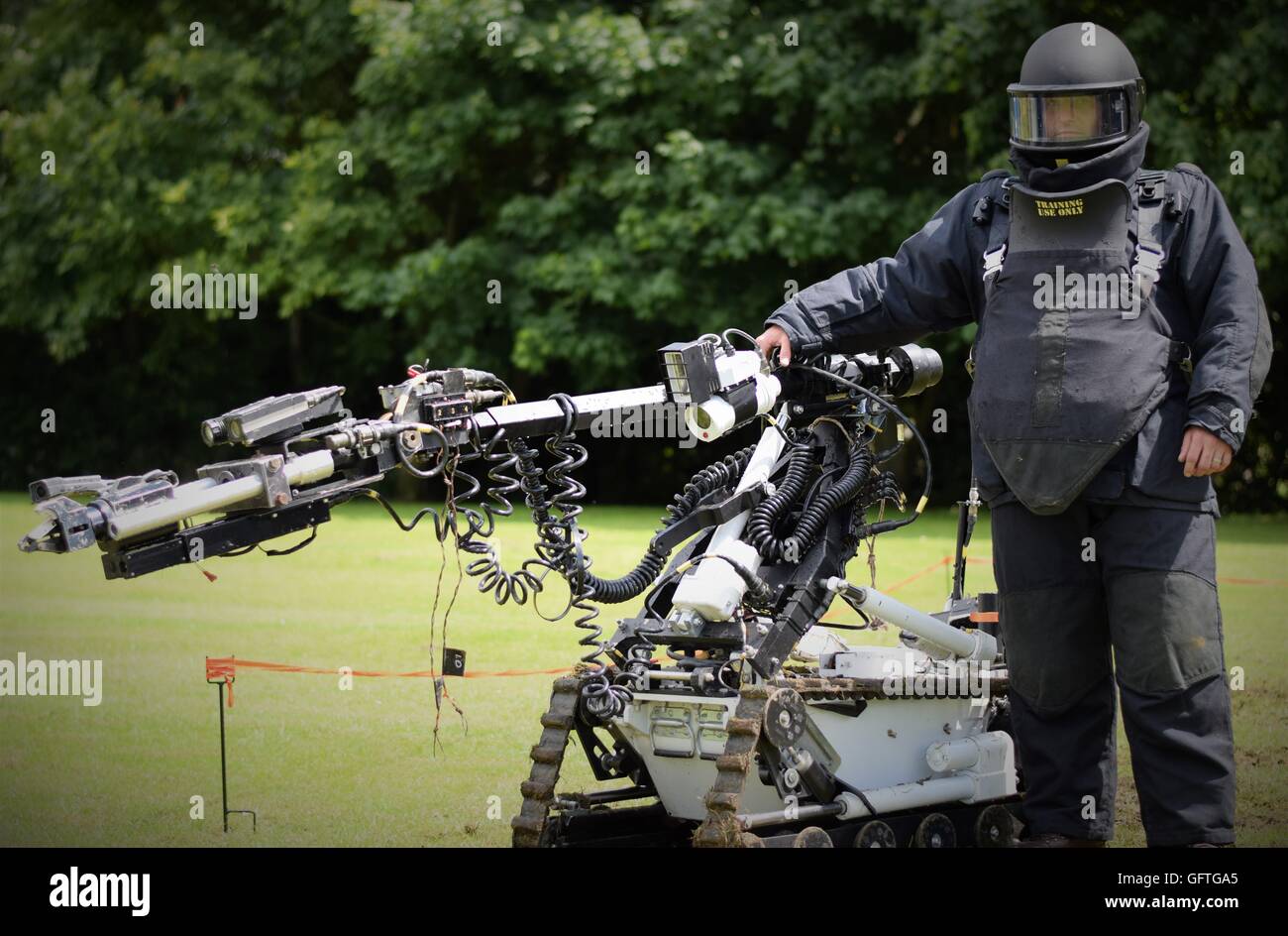 Kineton EOD (Explosive Ordnance Disposal) operator dressed in a bomb suit with a bomb-disposal robot. Stock Photo