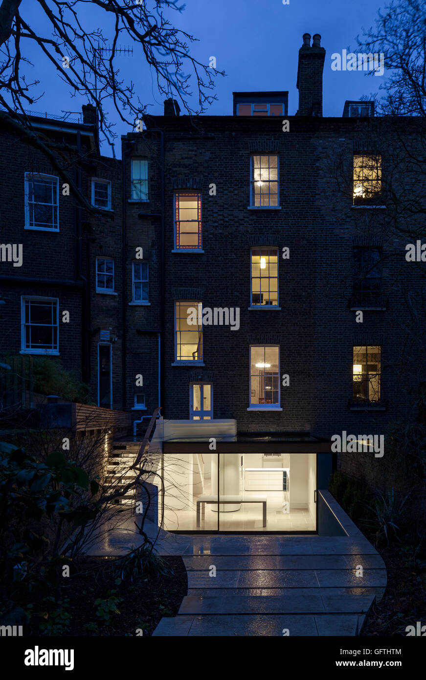 Ion over the extension, view of the rear elevation of the Georgian crescent terrace at night. Gloucester Crescent, London, United Kingdom. Architect: Barnaby Gunning Architects, 2014. Stock Photo