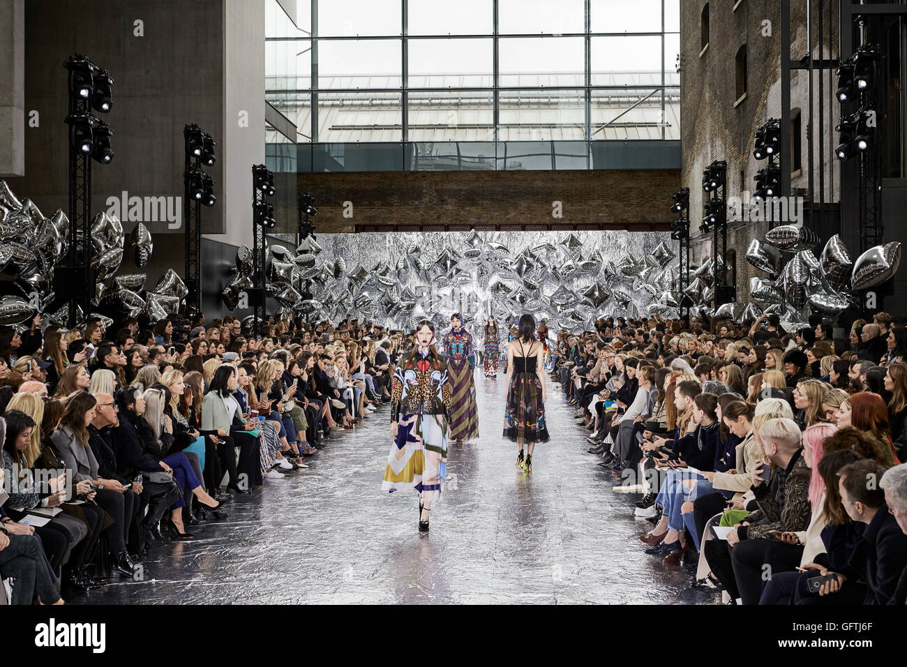 Double-height hall interior during fashion show with spectators ...