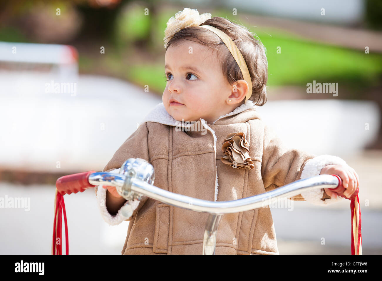 Little baby girl learning to ride a tricycle Stock Photo Alamy