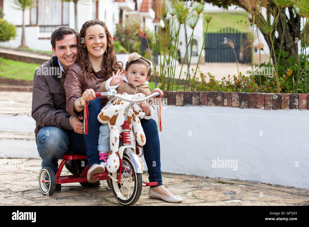 With mom and dad riding my tricycle Stock Photo Alamy