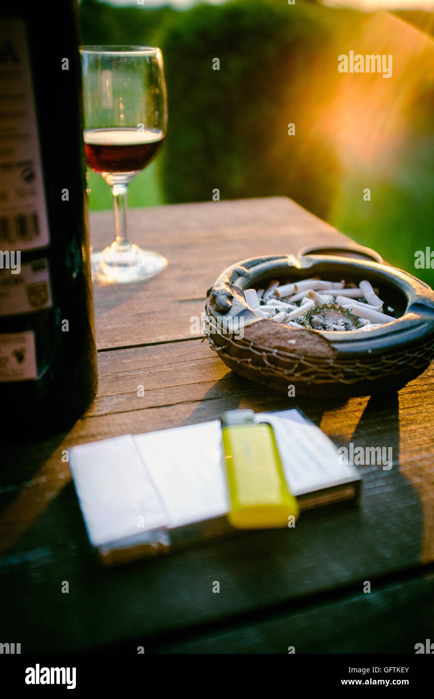 Cigarette and red wine during summer sunset evening on the tarrase Stock  Photo