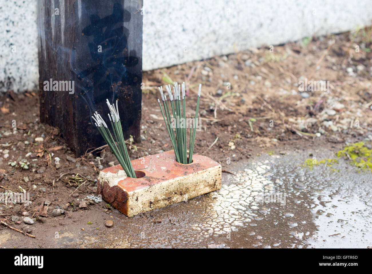 Japanese religious incense stick burning in the front of a grave Stock