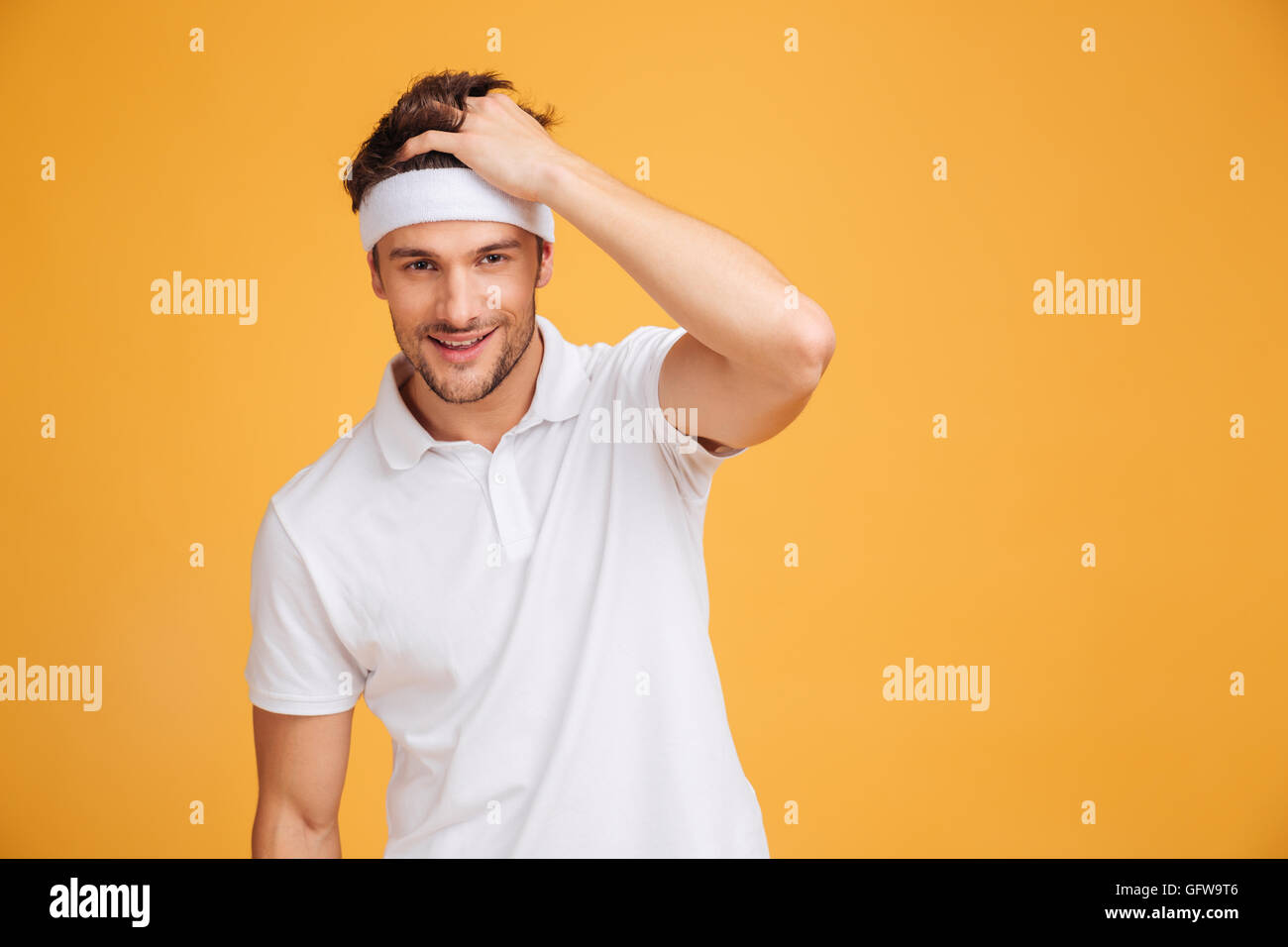 Portrait of smiling attractive young man athlete in headband over