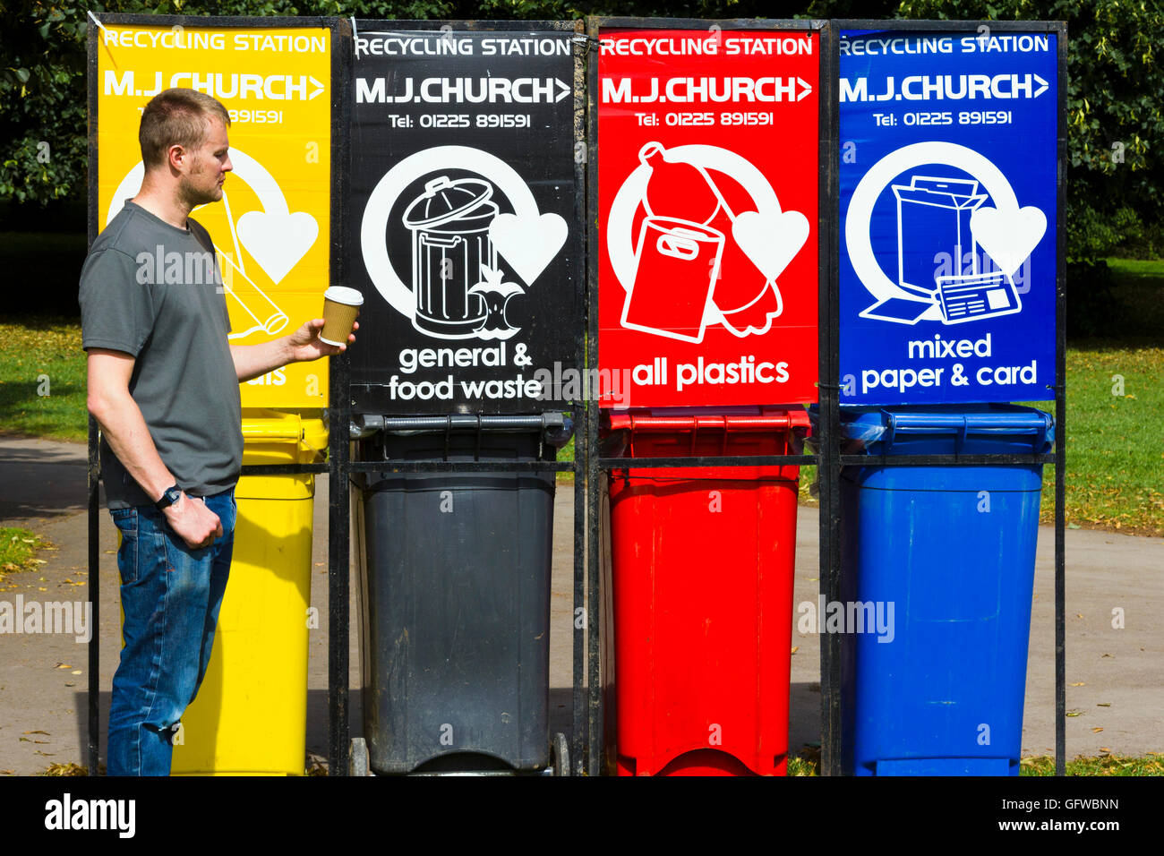 Man choosing which bin to put his paper coffee cup in Stock Photo Alamy
