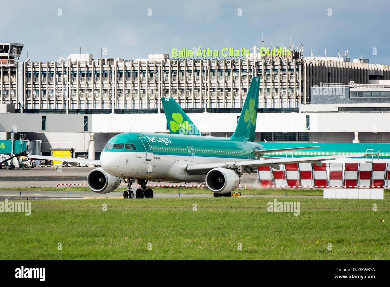 Aer Lingus plane on ground at Dublin airport with Dublin airport sign on terminal behind Stock Photo