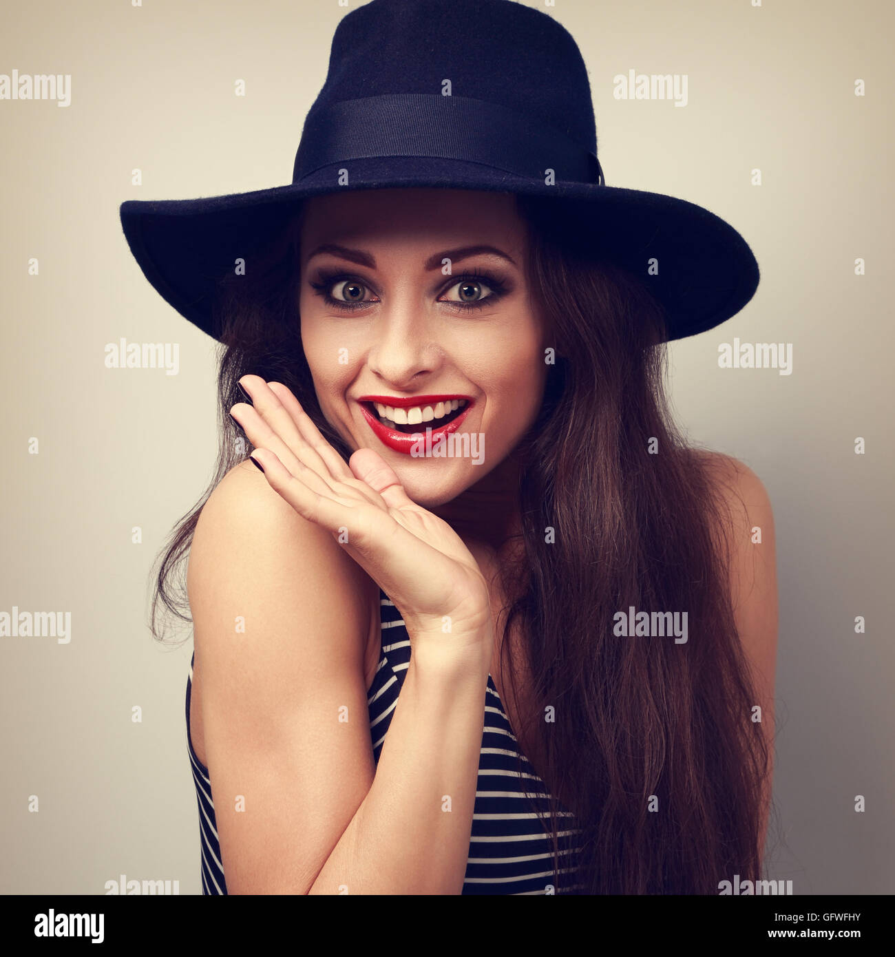 Happy bright makeup surprising woman looking funny in fashion blue hat. Toned vintage portrait Stock Photo