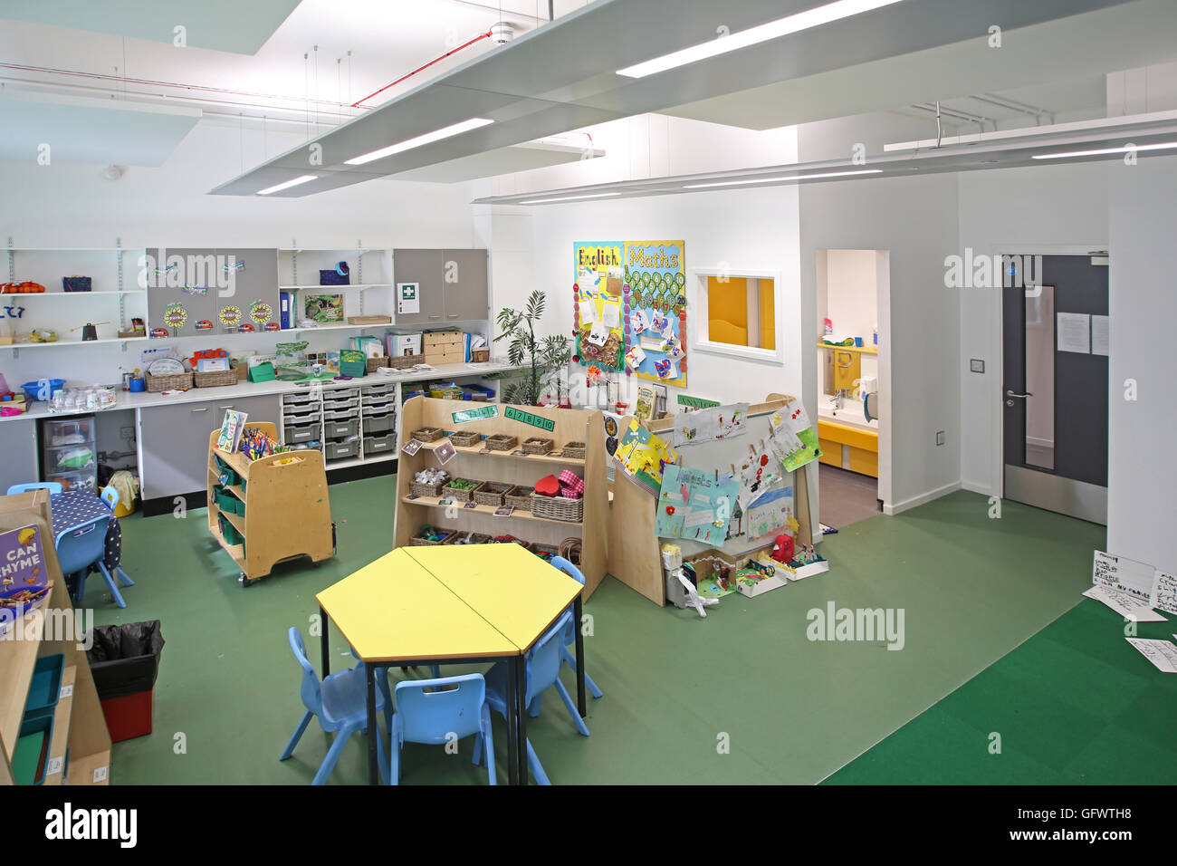 Nursery classroom in a new, London primary school. Shows desks and chairs with pupil's artwork on the walls Stock Photo