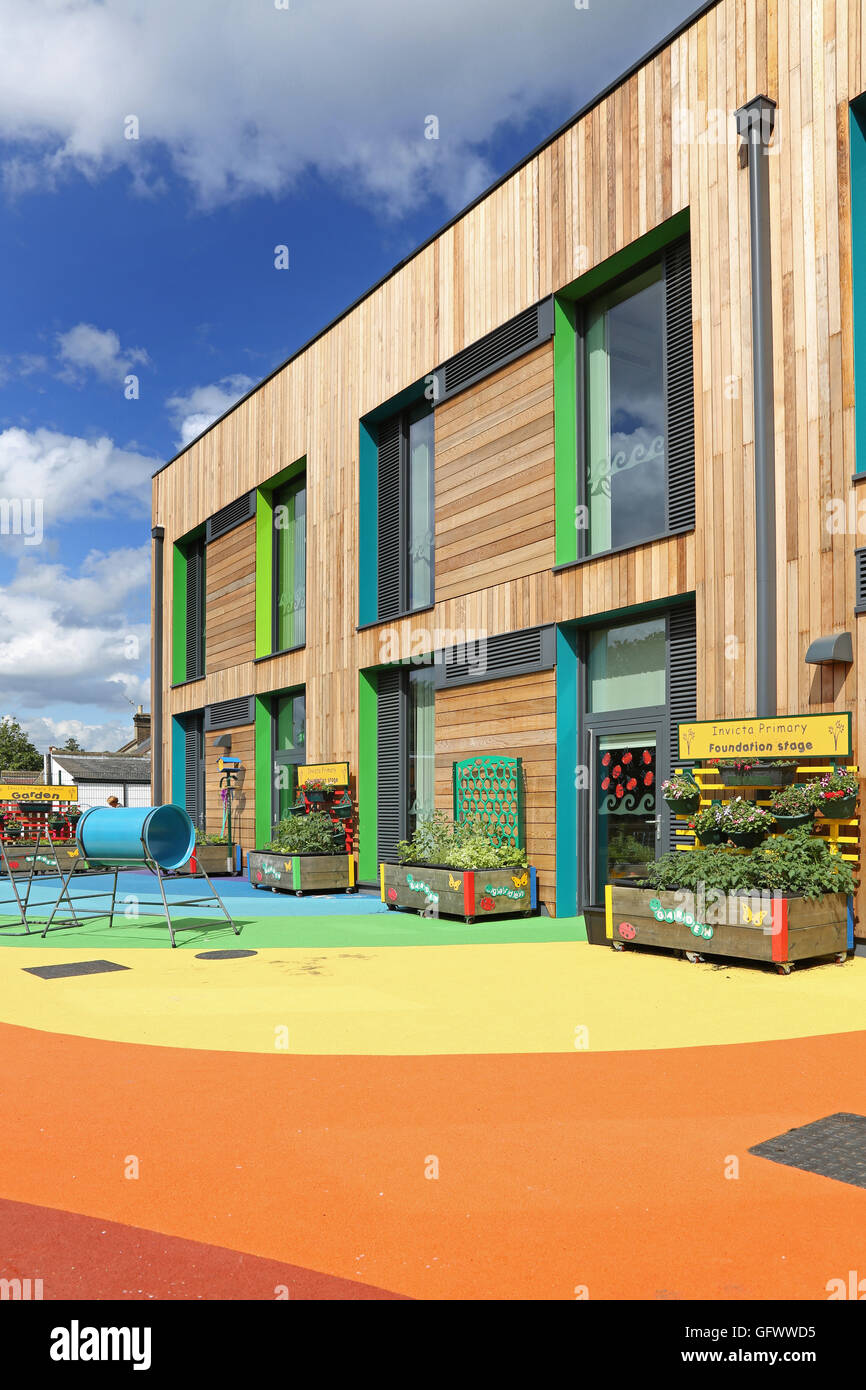 Exterior of Invicta Primary School in South London. A new timber-clad structure with  rainbow-coloured playground surface Stock Photo