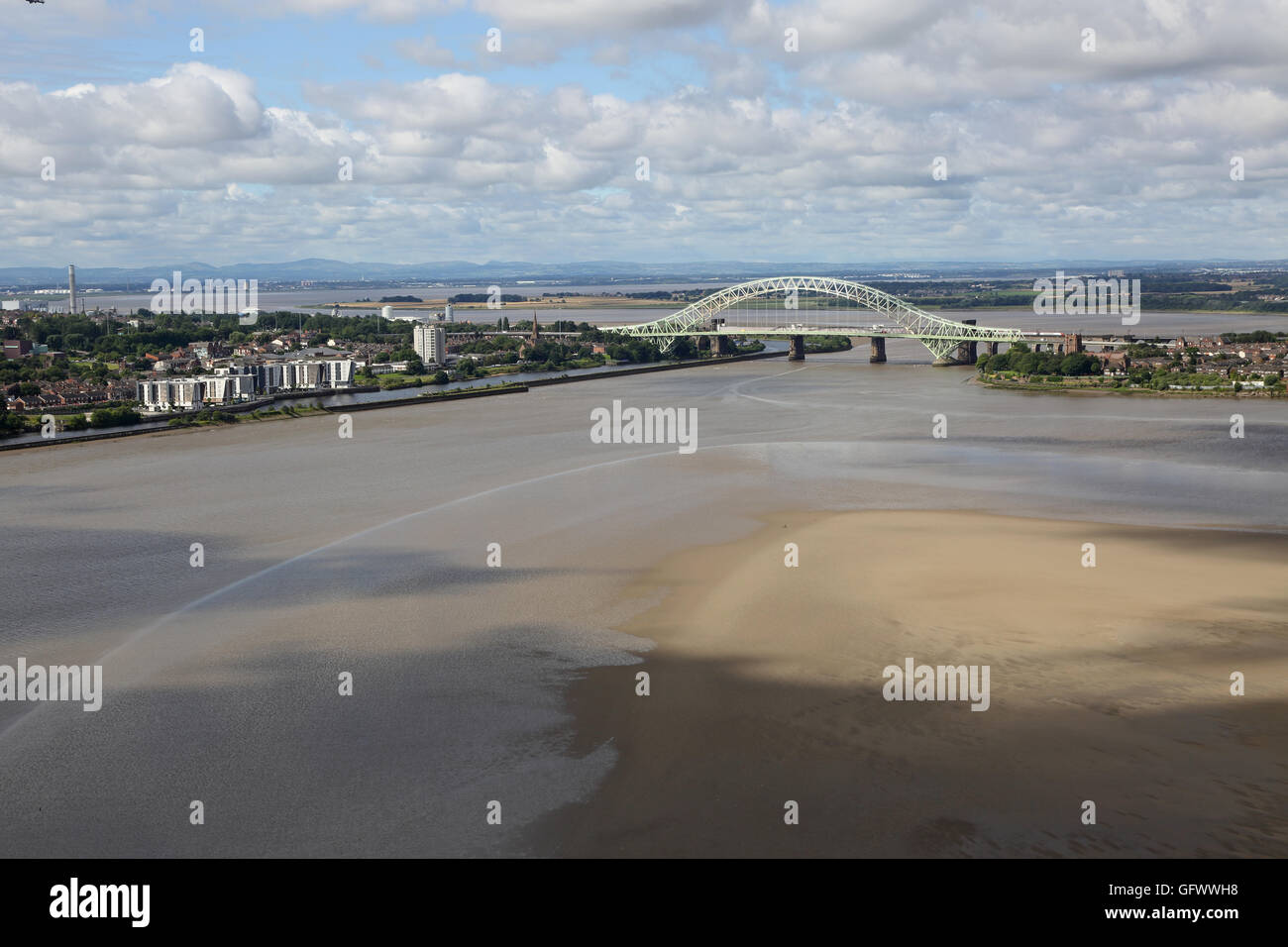 High-level view of the River Mersey at Runcorn showing the Silver Jubilee bridge, estuary mudflats and Welsh Mountains beyond Stock Photo