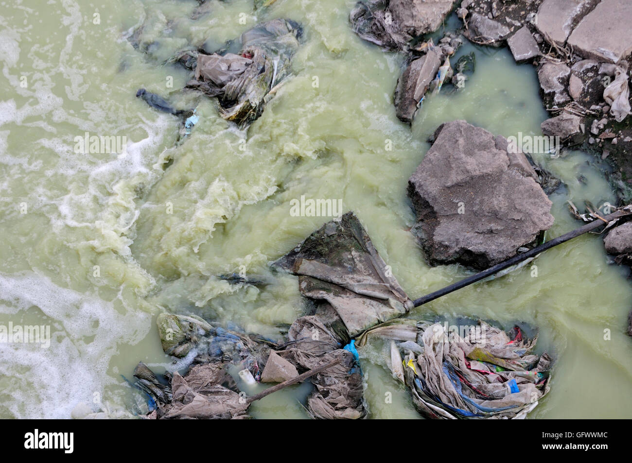 A water canal and run off area within Zhaodong China filled with trash creating polluted water in Heilongjiang province. Stock Photo