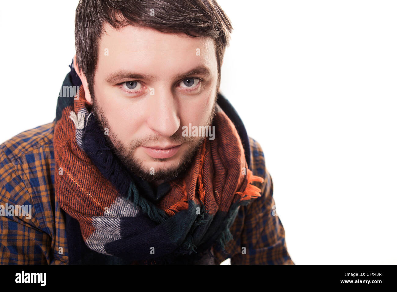 Man Cold . Ill young man with red nose, scarf, sneezing into handkerchief. Medication or drugs abuse, healthcare concept. Stock Photo