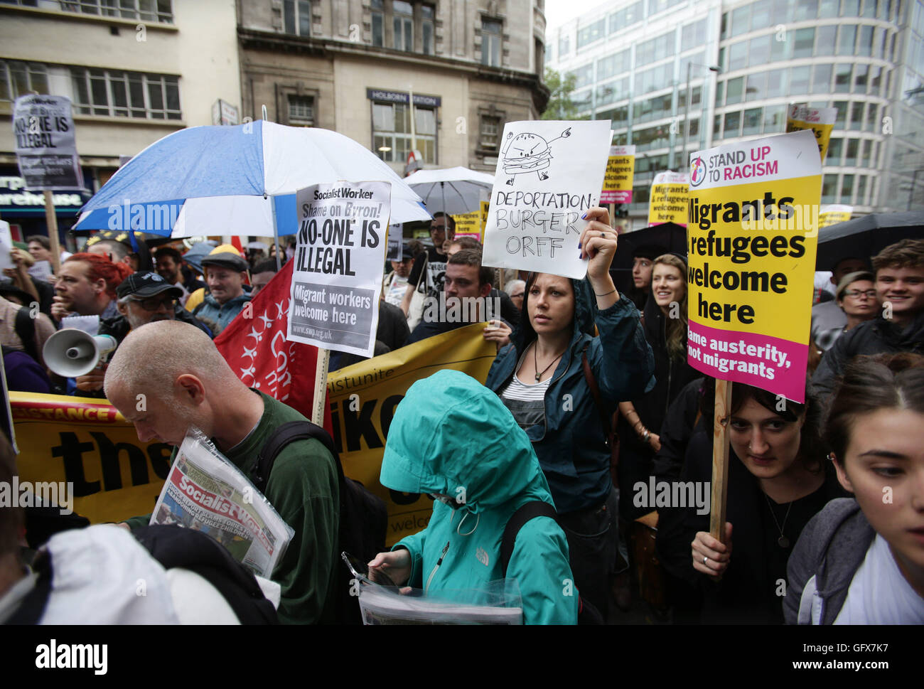 Protesters hold placards outside a Byron restaurant in Holborn, central London, as they take part in a demonstration after dozens of workers at the burger chain were arrested in a swoop by immigration officials. Stock Photo