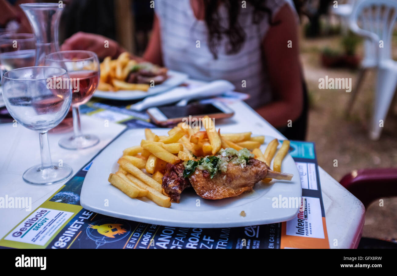 Confit of duck leg with French fries at restaurant Stock Photo