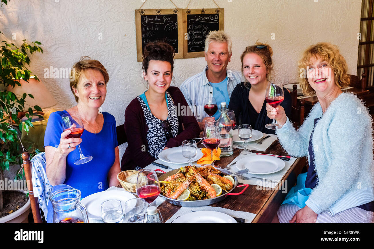 Family and friends eating out at Paella Restaurant South West France Midi Pyrenees July 2016 Stock Photo