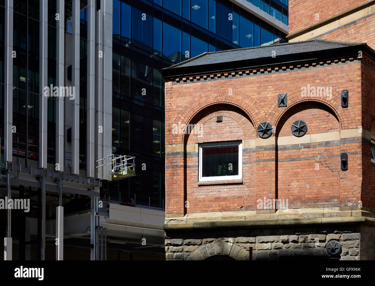 arched brickwork of old building contrasted with modern building of Central Square, Leeds Stock Photo