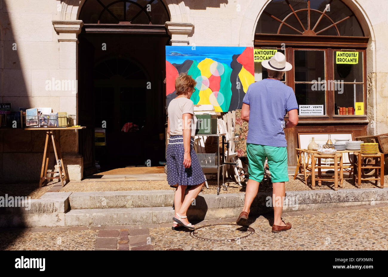 Couple looking at artwork to buy while on holiday Puy L'Eveque  Lot Region South West France Stock Photo