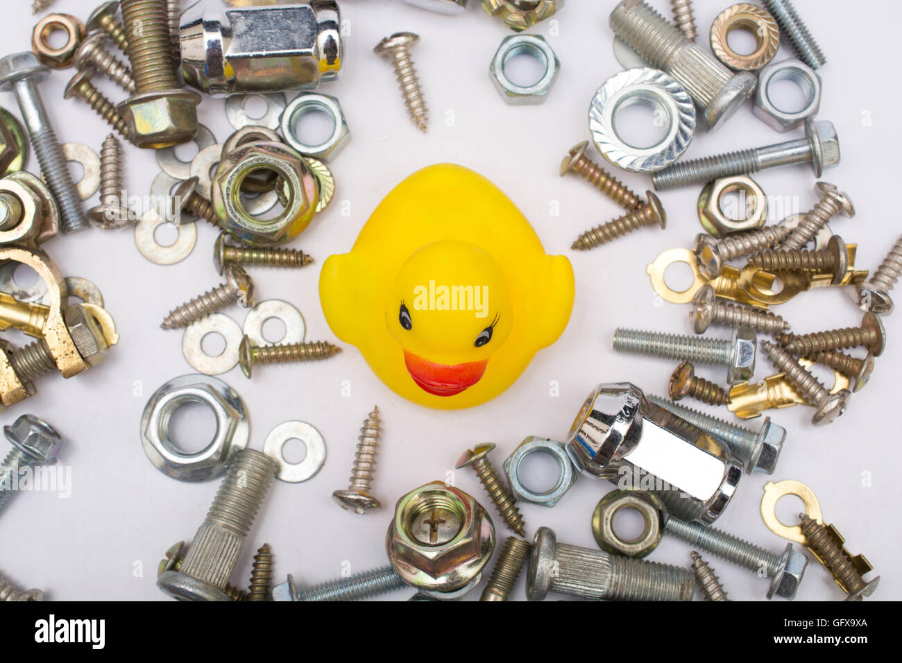 Yellow Duck between hardware nut bolts. Difficulty concept. Stock Photo