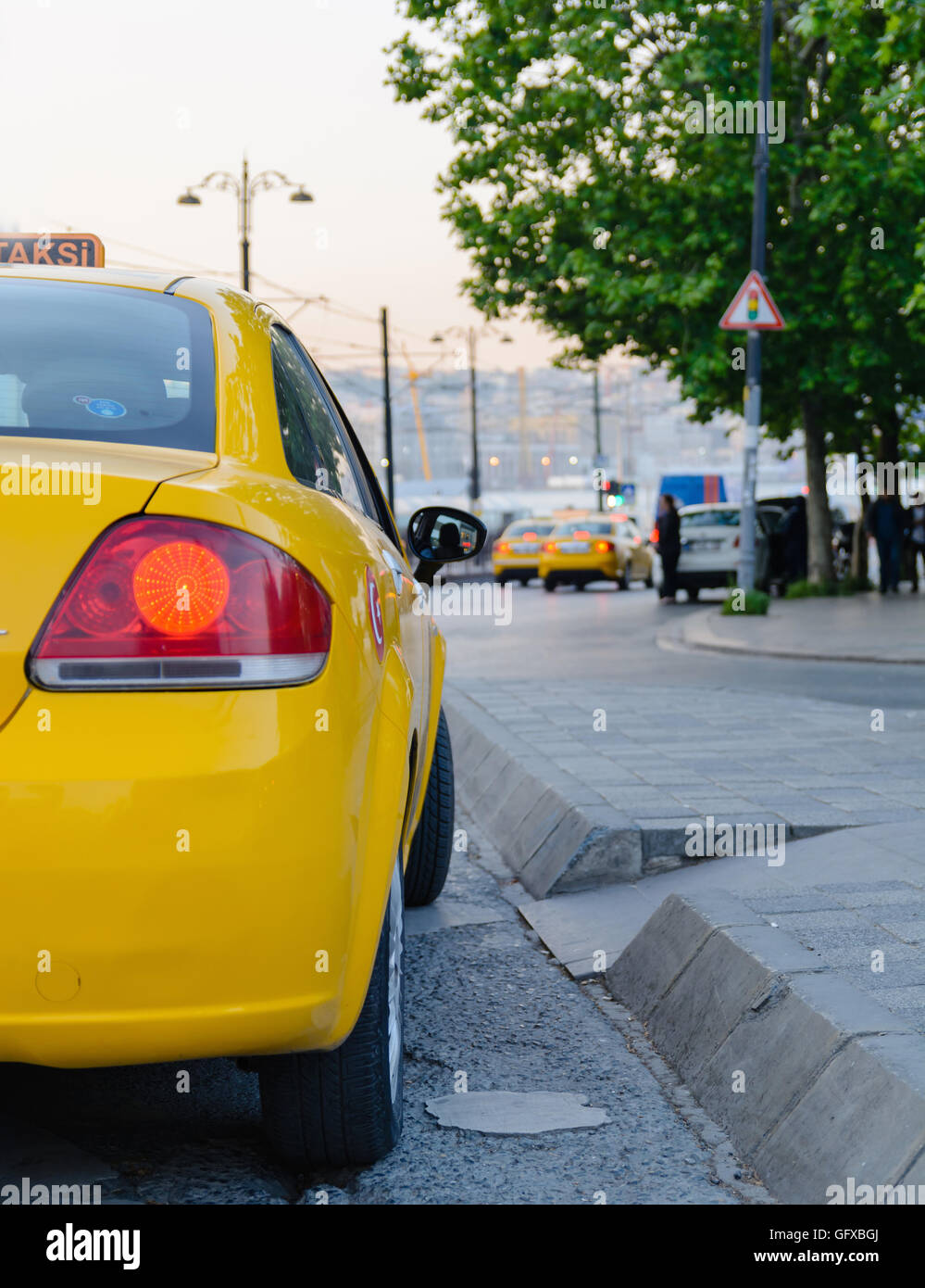 Red brake light yellow taxi on a background of an evening Stock Photo
