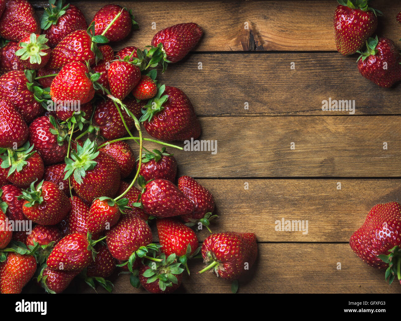Strawberries over natural wooden background Stock Photo - Alamy